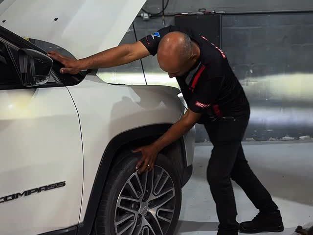 Mecânico no capô de um carro automático